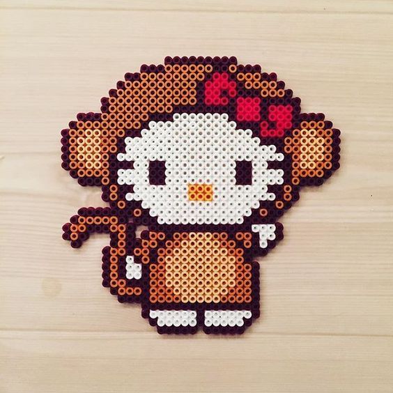 a cross - stitch pattern of a hello kitty with hearts on her head, sitting on a wooden surface