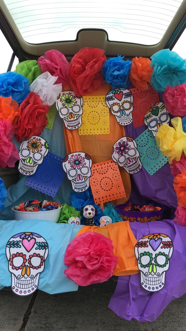 a car decorated with colorful tissue paper and sugar skulls on it's back seat