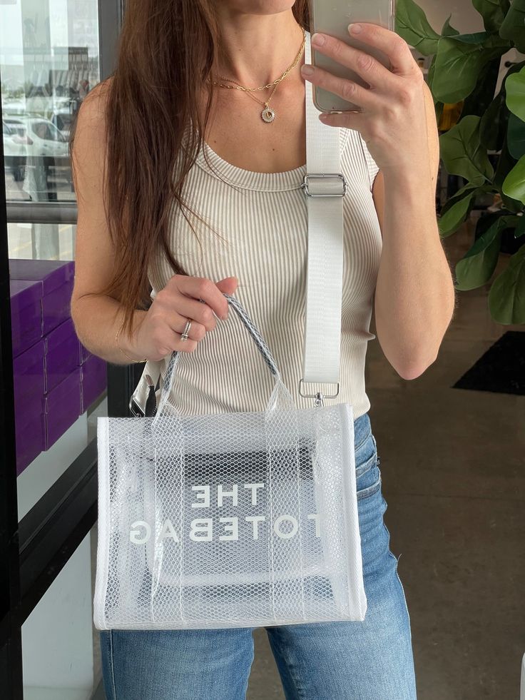 This inspired CLEAR tote bag will be the prefect accessory for all things concert, stadium events, and sporting events this summer (or any time of year). Adjustable strap Easy to clean 10.63" x 4" x 8.27" Preorder items will ship approx 14 business days from order. Summer White Shoulder Bag For On-the-go, Medium White Shoulder Bag For Travel, Trendy Rectangular Mesh Bag, Trendy Rectangular Mesh Bags, Trendy Mesh Bag For Daily Use, Summer School Mesh Bags, Mesh Tote Bag For Daily Use, Casual Mesh Tote Bag, Summer Mesh Bag For Daily Use