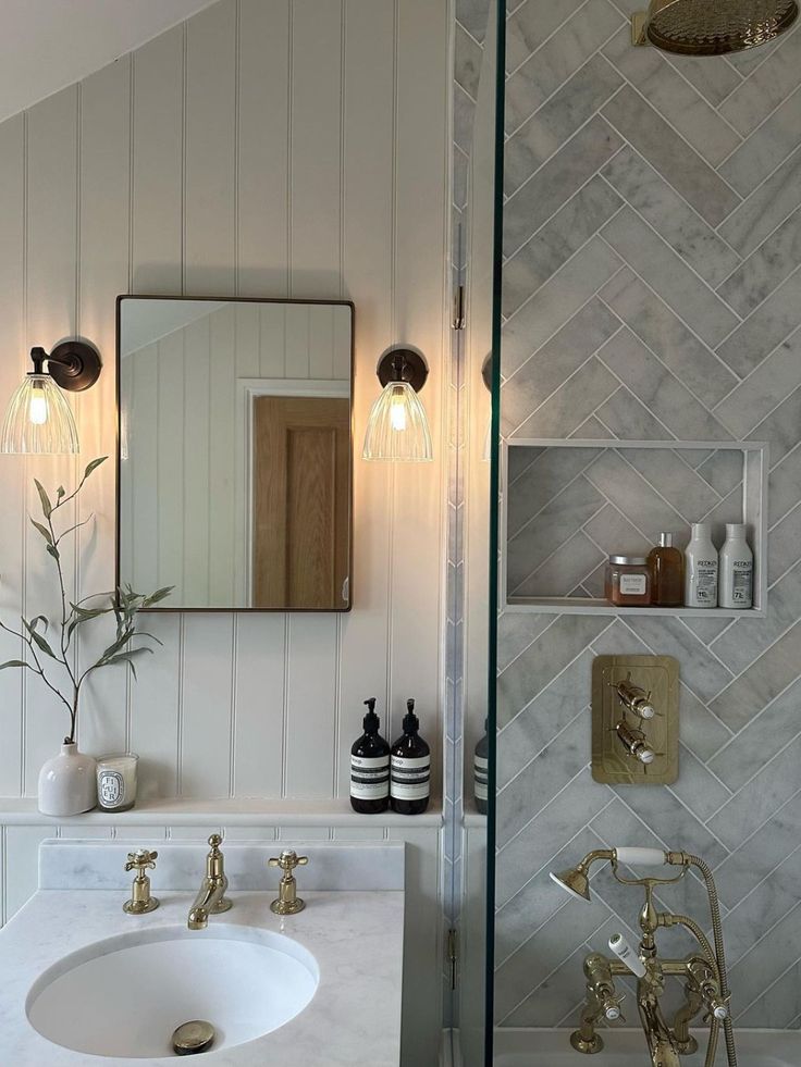 a bathroom with marble counter tops and gold faucets