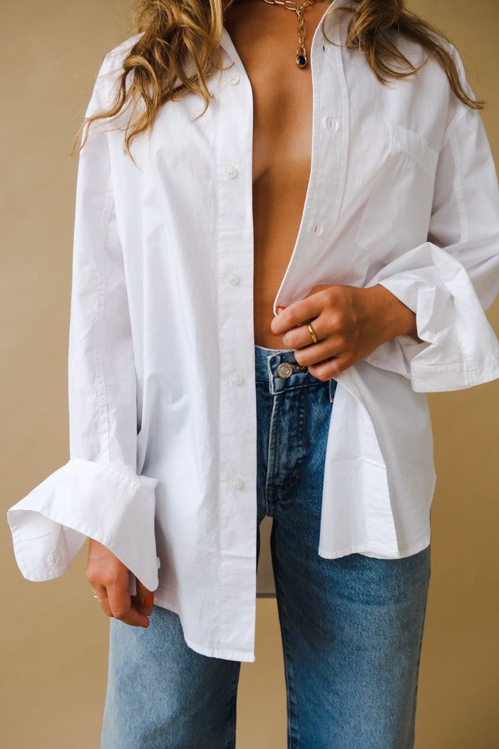 Citizens of Hummanity Kayla button up shirt in optic white. An oversized silhouette and high-low hem give new dimension to a timeless staple. Buttons on sleeve to give loose rolled up sleeve effect. This fit is intended to be relaxed. Size down for a closer fit. Body Length: 30 1/4", Shoulder to Shoulder: 19 3/4", Sleeve Length: 22" Model is 5'10" and wearing a size Small.100% Cotton. Machine wash inside out.Made in Vietnam with imported materials 9103C-741 PIPE AND ROW Refined Fashion, American Landscape, Chic Blazer, Crisp White Shirt, Perfect Jeans, Oversized Silhouette, Citizens Of Humanity, White Shirts, Fit Body