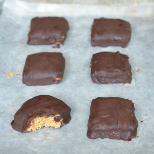 six pieces of chocolate and peanut butter on a cookie sheet