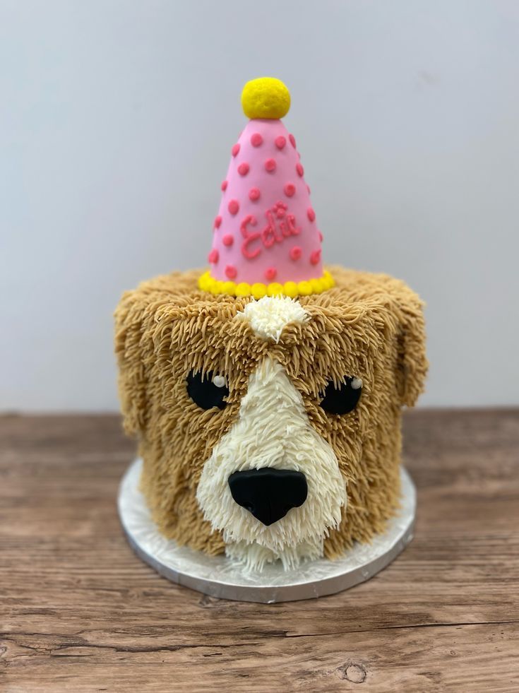 a cake shaped like a dog wearing a birthday hat