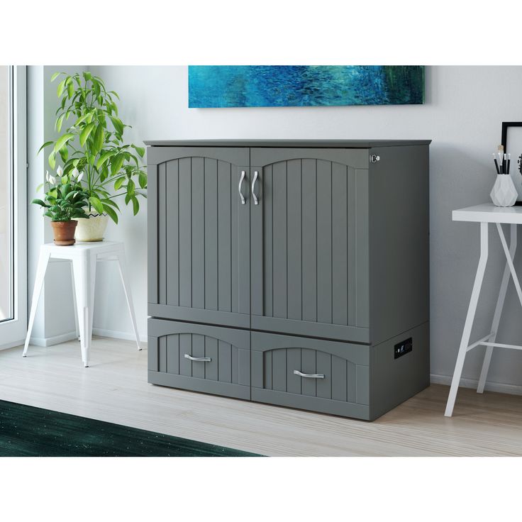 a large gray cabinet sitting next to a white table with a potted plant on it