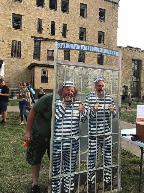 two men in jail suits standing behind a cage