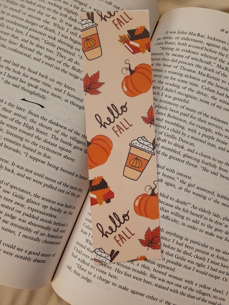 an open book with a fall themed neck tie on it's cover that says hello fall