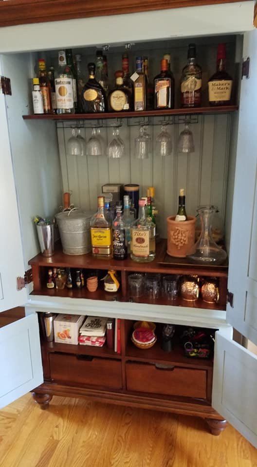 an open cabinet filled with liquor bottles and glasses