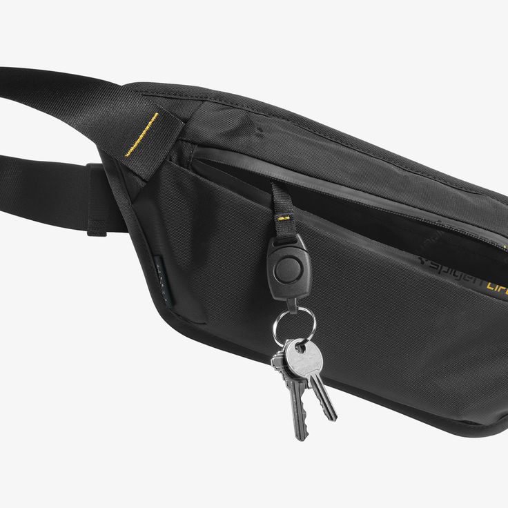 a black fanny bag with two keys hanging out of it's side pocket on a white background