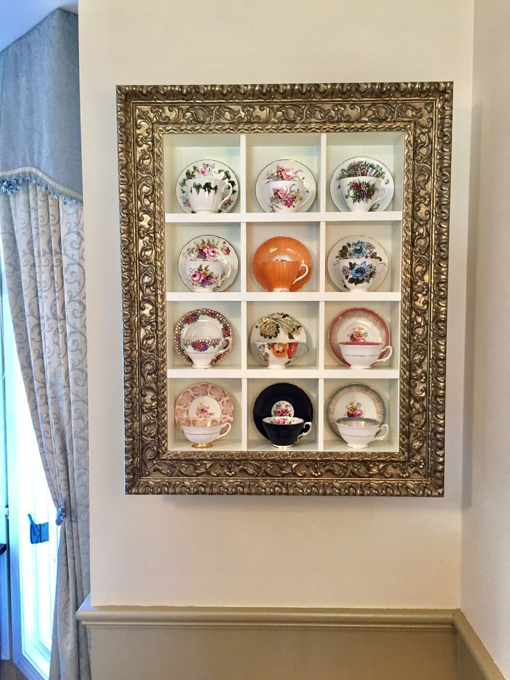 there is a wall with many plates on it in the room and one has a gold frame