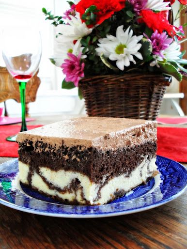 a piece of cake sitting on top of a blue plate next to a vase with flowers