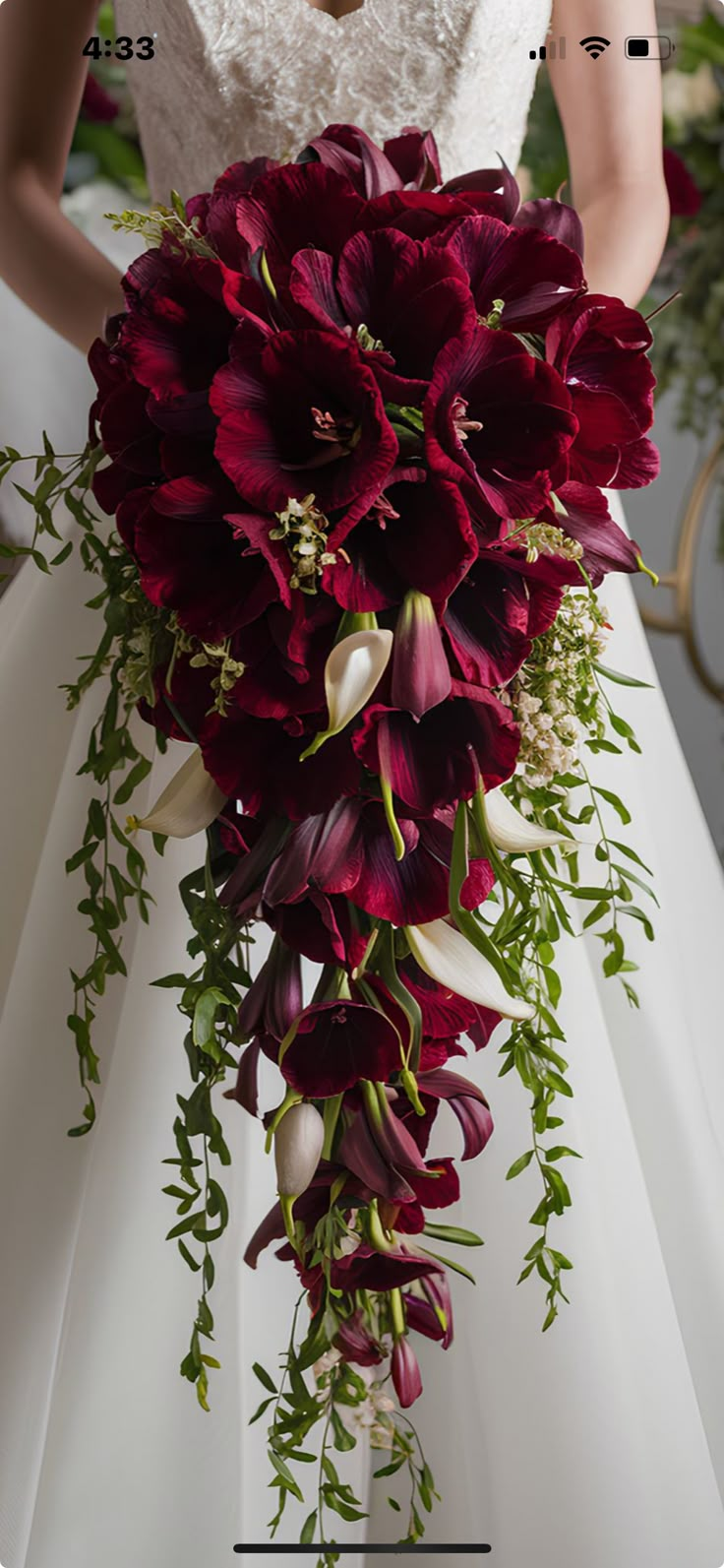 a bride holding a bouquet of red flowers