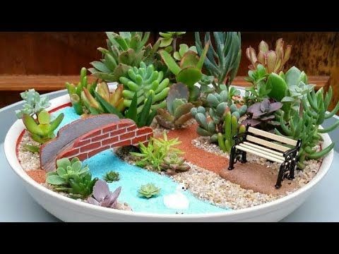 a miniature garden is displayed in a bowl