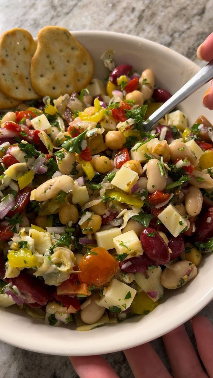 a white bowl filled with salad and crackers