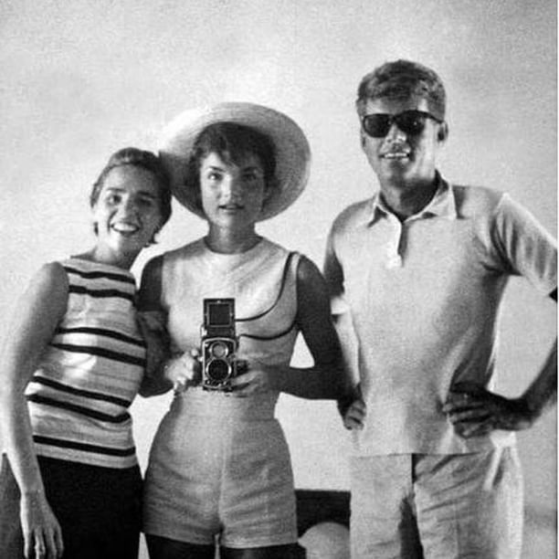 an old black and white photo of two women and a man with a camera in their hands