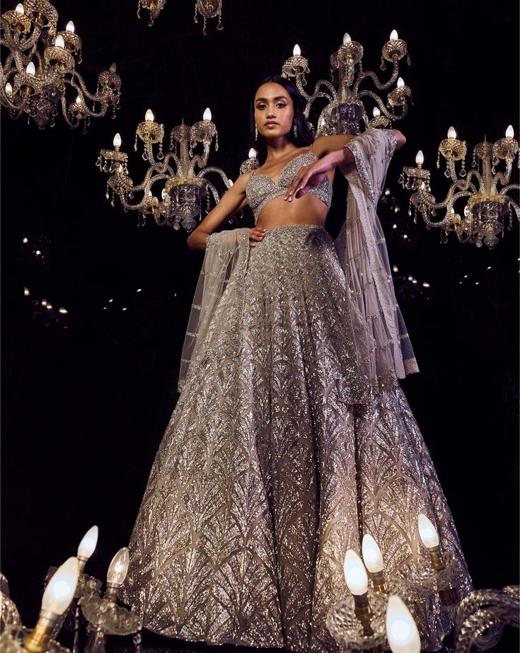 This lehenga set features platinum cut sequin and crystal embellishment in a cascade motif pattern. The ensemble is paired with a criss-cross back and fully embroidered net dupatta.From Seema Gujral's Tuscan Summer collection. DELIVERY TIMEPlease allow 4 months for your outfit to arrive. FABRIC DETAILSNet Professional cleaning only. Champagne Lehenga, Pretty Lehengas, Silver Lehenga, Beautiful Lehengas, Gota Patti Lehenga, Tuscan Summer, Strappy Blouse, Grey Lehenga, Sequin Lehenga