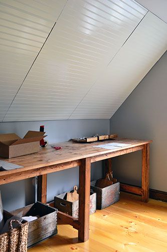 a room with a wooden table and storage bins on the floor next to it