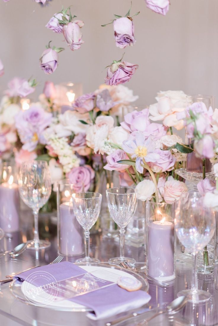 the table is set with purple and white flowers