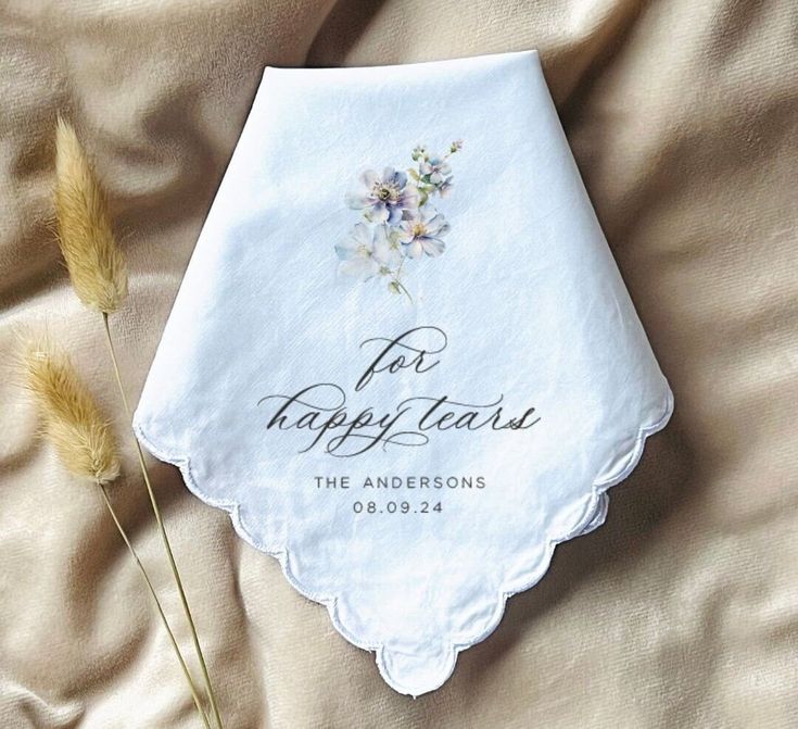 an embroidered handkerchief with flowers on it and the words for happy tears written in cursive writing