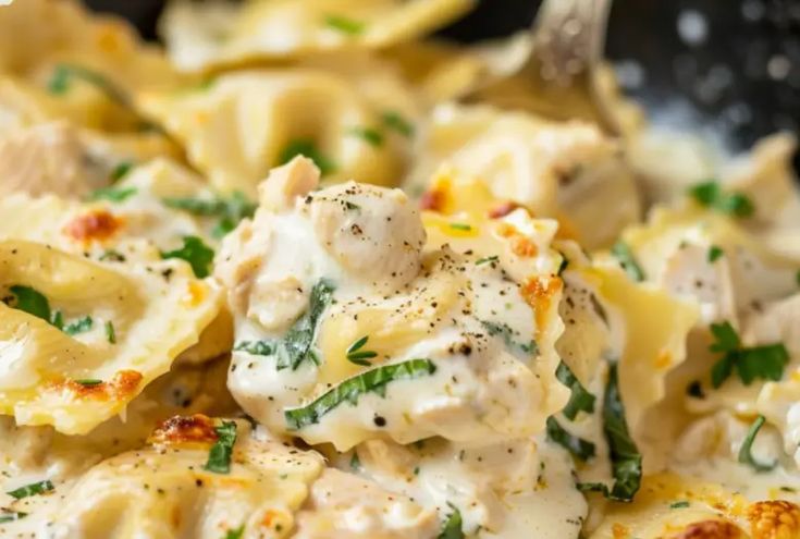 pasta with chicken and cream sauce in a skillet, ready to be eaten by someone