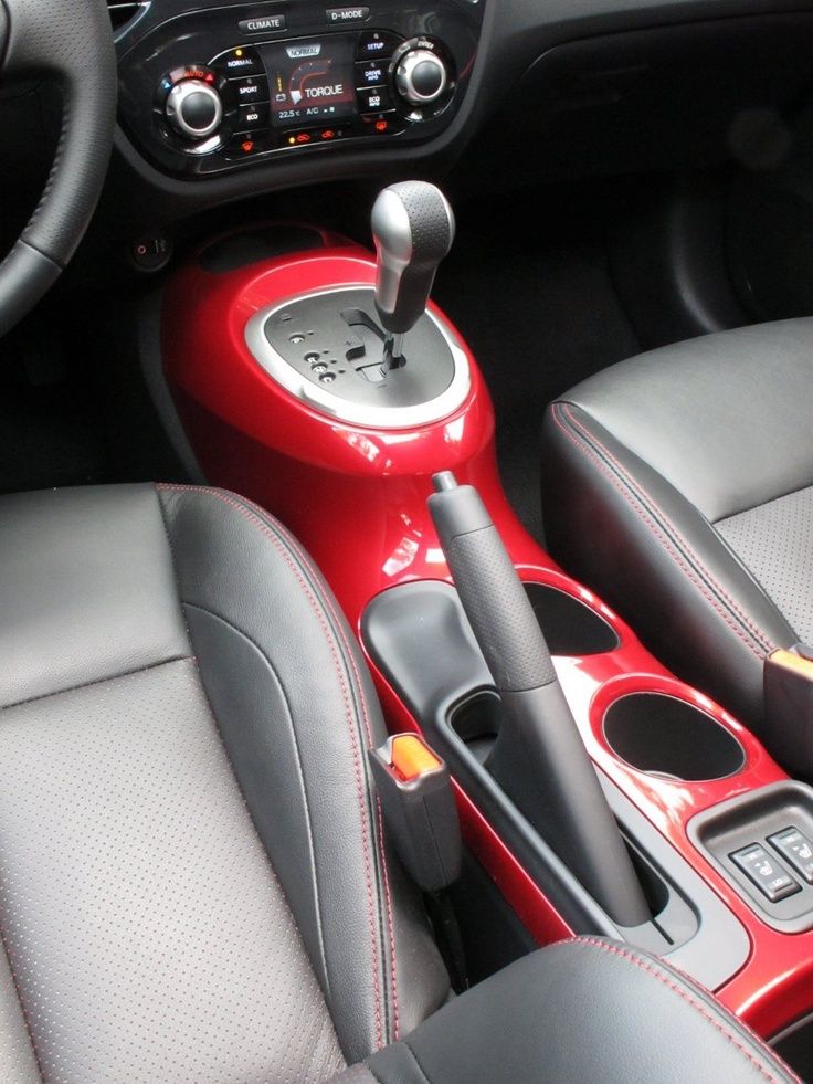 the interior of a car with red and black leather trims, steering wheel controls and center console