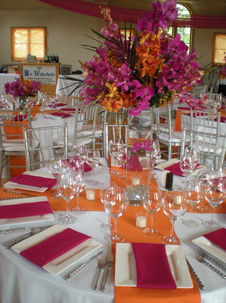 the tables are set with place settings and flowers in vases on top of them