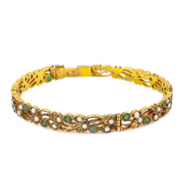 Rendered in yellow gold includes lustrous seed pearl and round cut emeralds. A delightful Art Nouveau design. Gemstone Details: Yellow Gold Seed Pearls Round Emeralds Total carat weight: 1.26 Emerald and Seed Pearl Bangle available at Burdeen's Jewelry. We have many unique offerings of fine estate jewelry listed on our Etsy store. Consider browsing all styles. Call us today for any questions 847-459-8980! All carat weight is estimated unless otherwise stated above. Elegant Jeweled Gold Bangle, Yellow Gold Jeweled Bracelet For Formal Occasions, Elegant Gold Jeweled Bangle, Elegant Jeweled Yellow Gold Bracelet, Yellow Gold Jeweled Bracelets For Formal Occasions, Jeweled Yellow Gold Bracelets For Formal Occasions, Formal Yellow Gold Jeweled Bracelets, Vintage Green Bangle For Wedding, Jeweled Yellow Gold Bangle Bracelet