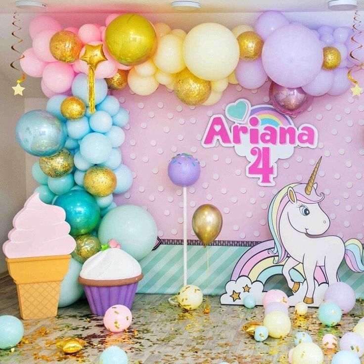 a birthday party with balloons, cupcakes and unicorn themed decorations on the table