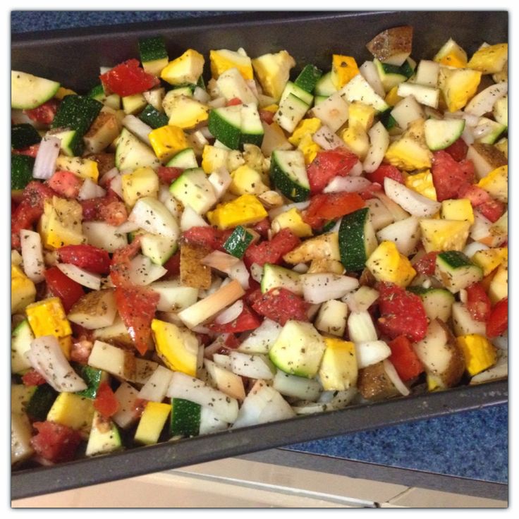 a pan filled with chopped vegetables sitting on top of a blue countertop next to a stove