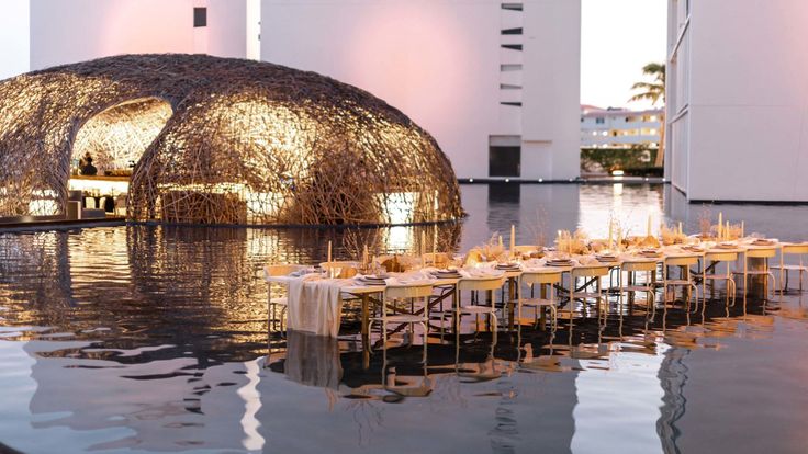 an outdoor dining area with tables and chairs in the water