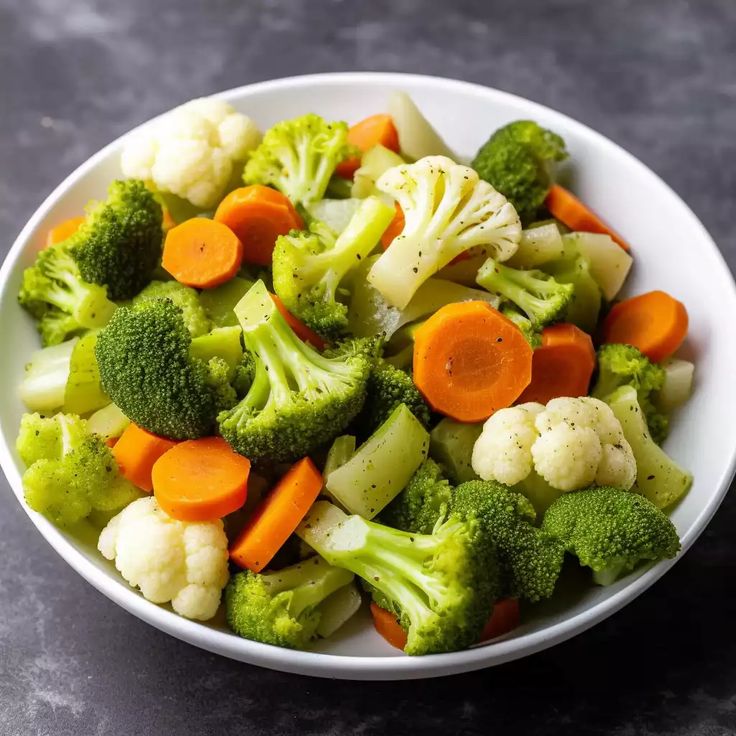 a bowl filled with broccoli, cauliflower and carrots