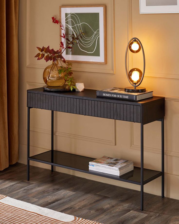 a black console table with a lamp on top