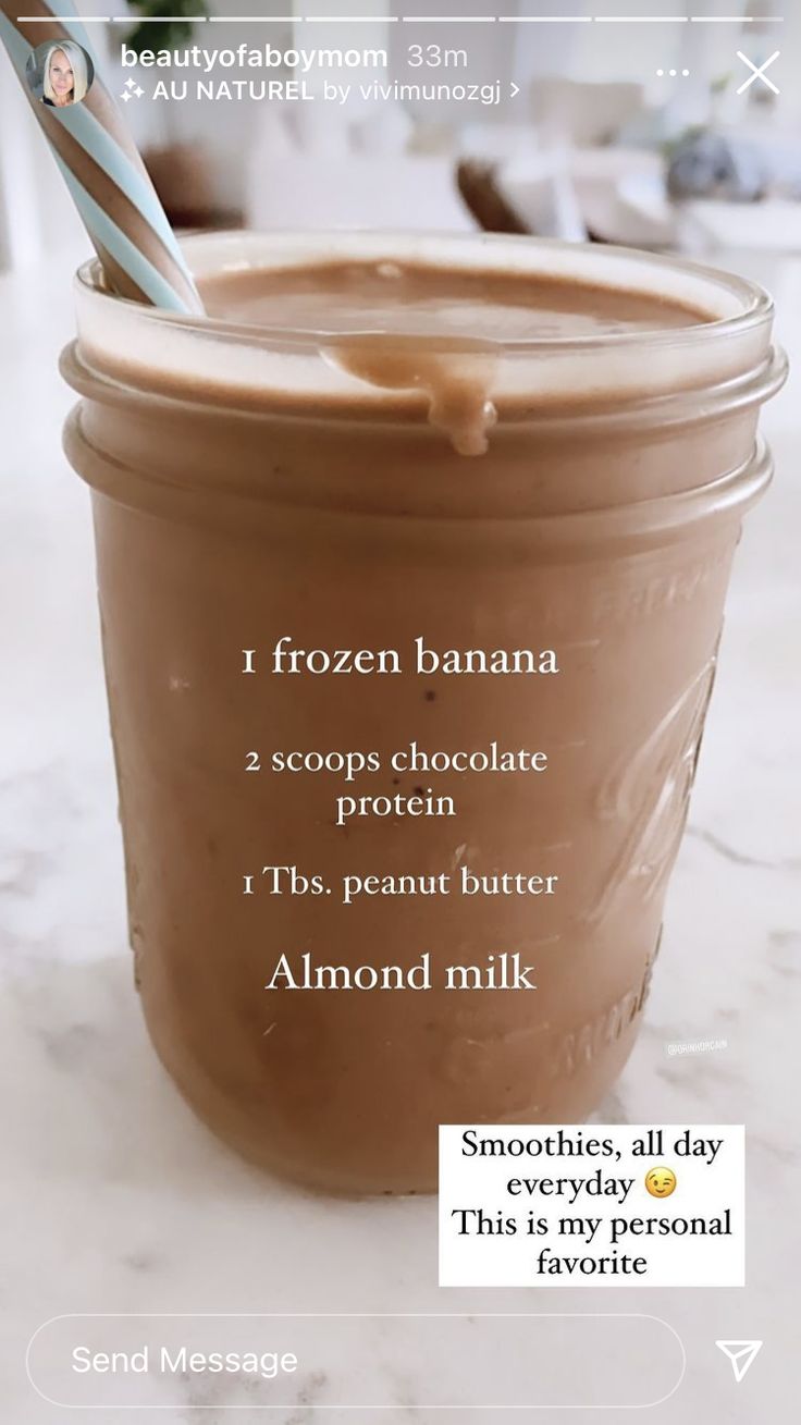 a glass jar filled with chocolate pudding on top of a white marble counter next to a blue and white striped straw