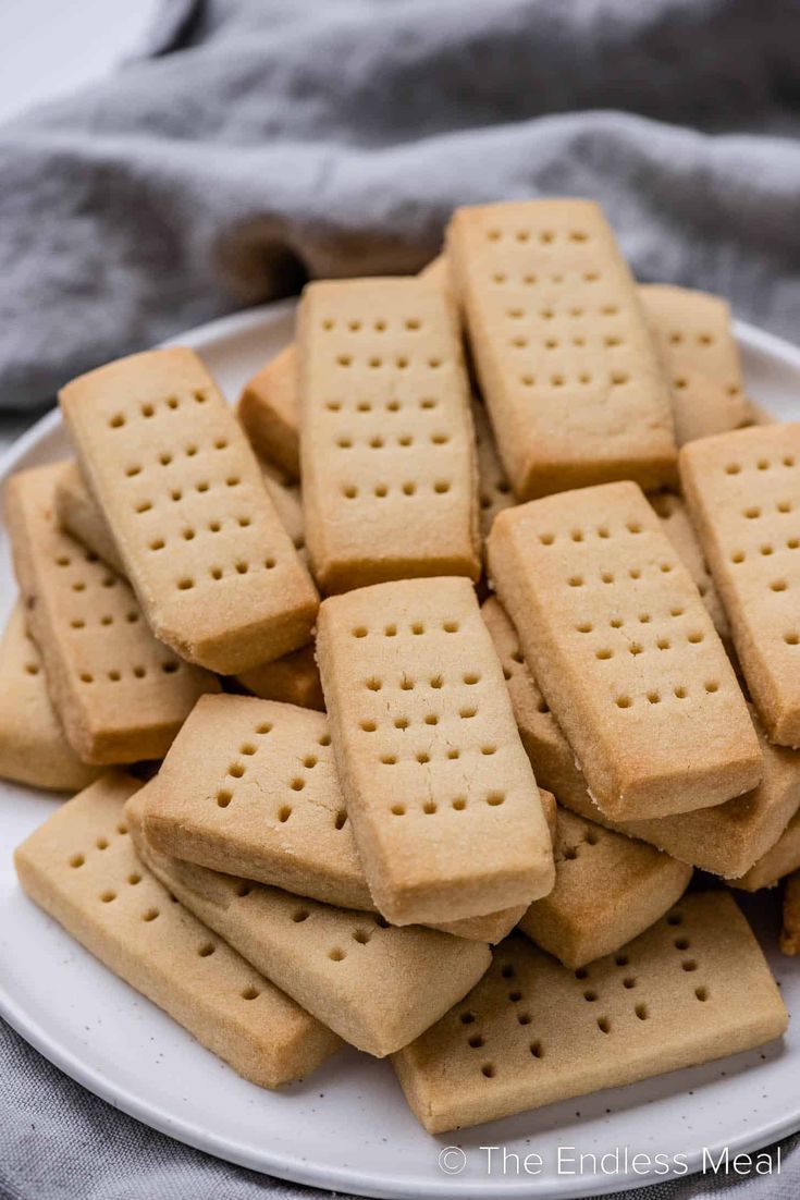 a white plate topped with crackers on top of a gray cloth covered tablecloth