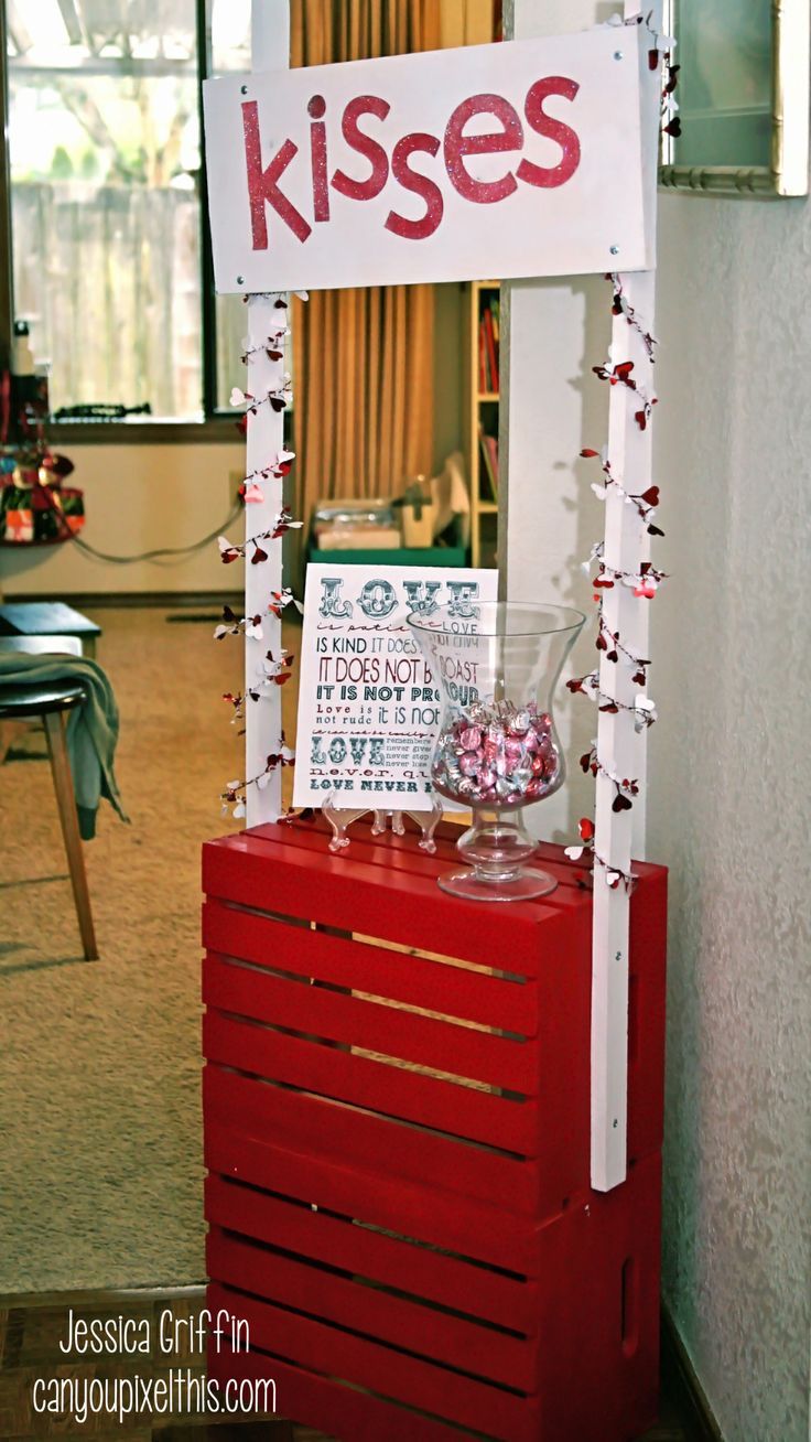 a sign that says kisses on top of a red crate in front of a window