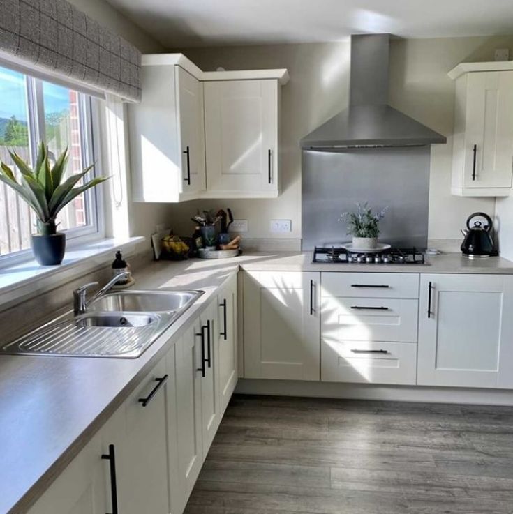 a kitchen with white cabinets and stainless steel appliances