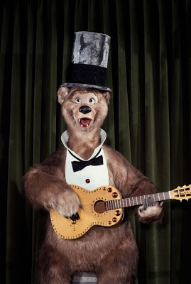 a bear with a top hat holding a guitar