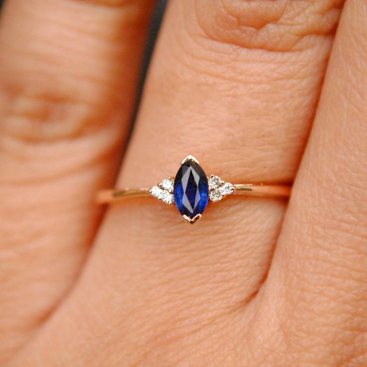 a woman's hand with a diamond and blue sapphire ring