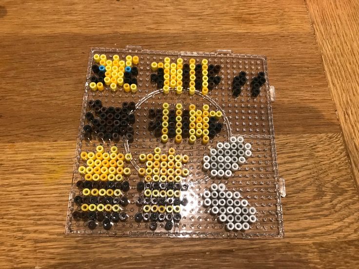 an array of bead designs sitting on top of a wooden table