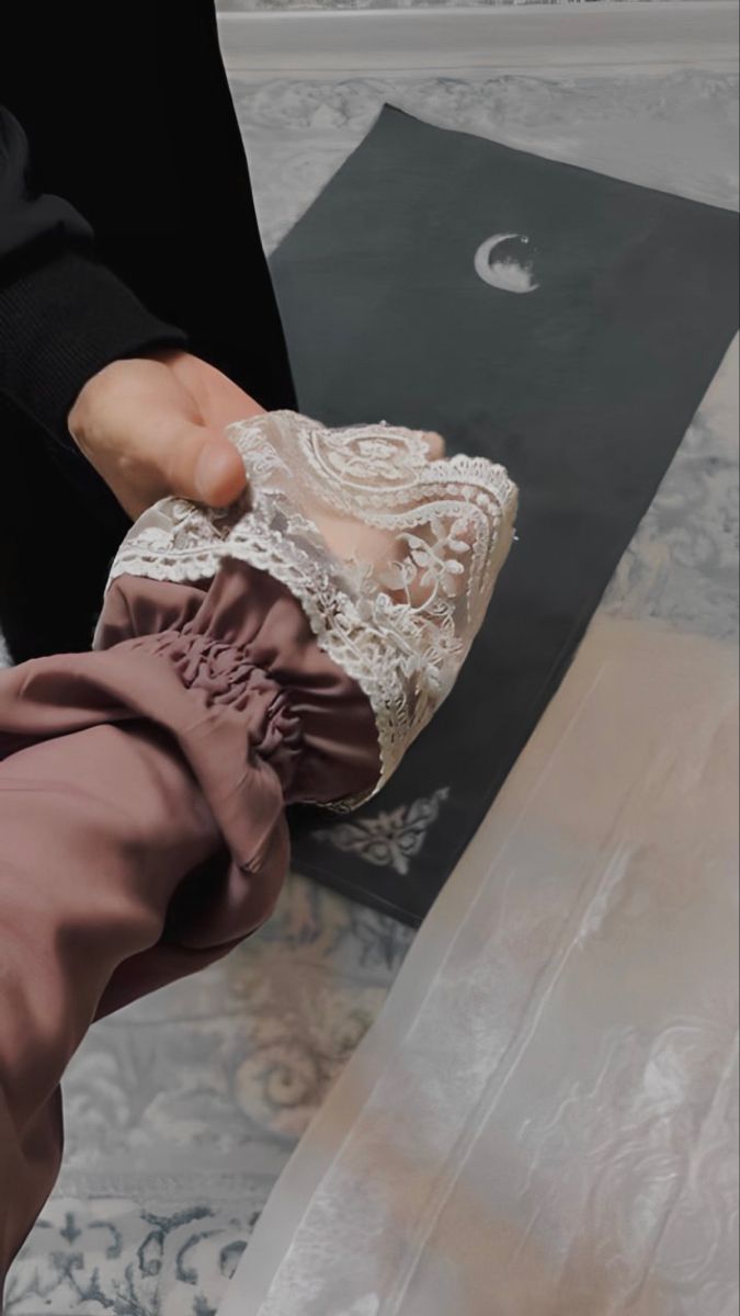 a person holding something in their hand on top of a carpeted floor next to a rug