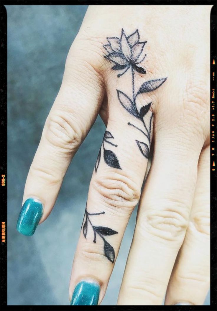 a woman's hand with a flower tattoo on it