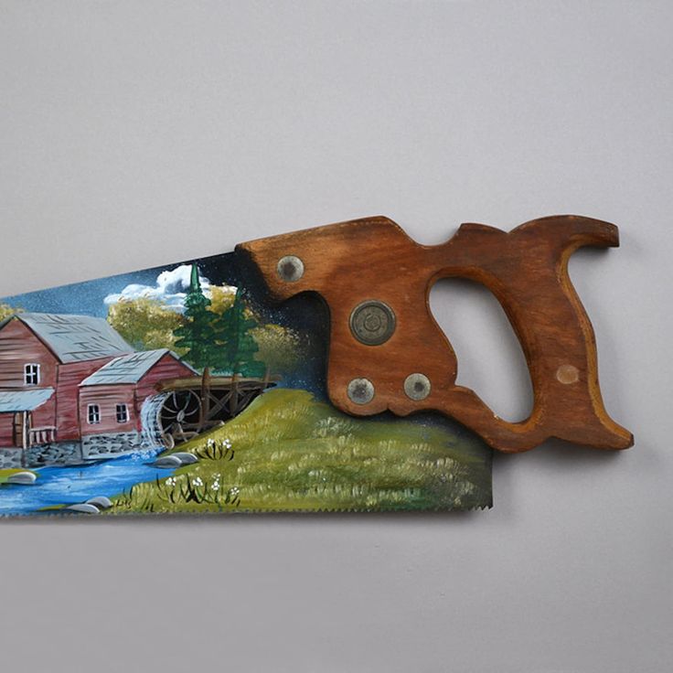 a knife with a painting on the side of it that is cut in half to look like a farm scene