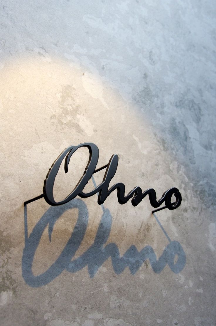 the word ohno is casting a shadow on the concrete floor next to it's name