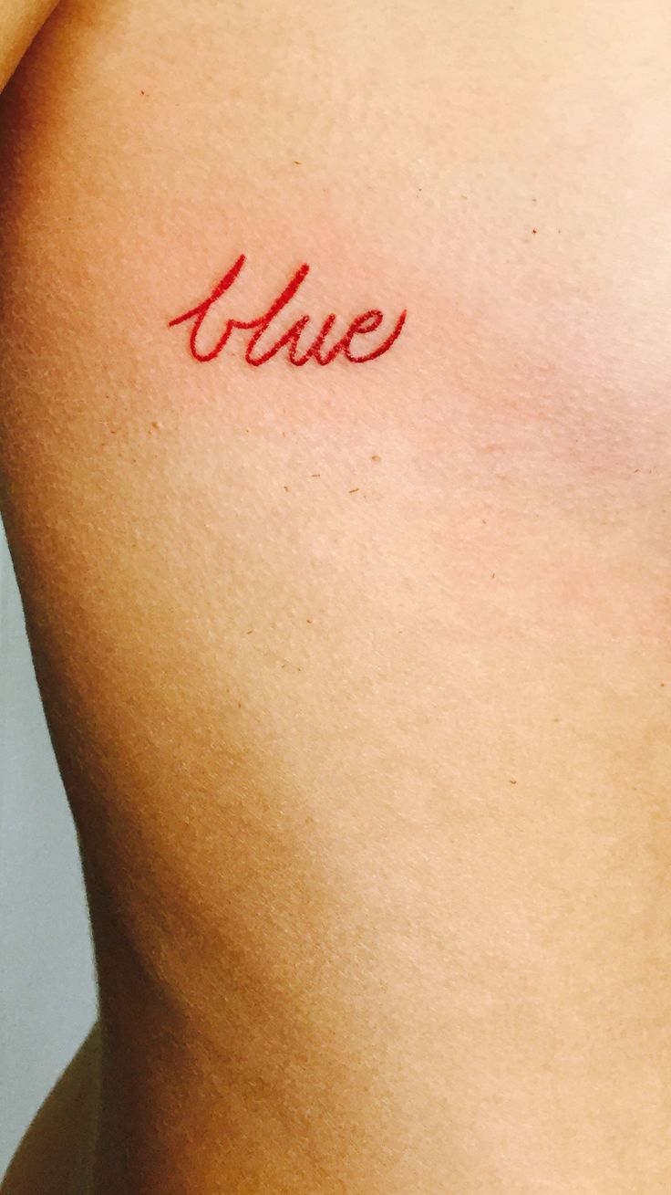 a woman's chest with the word love tattooed on her left side ribcage