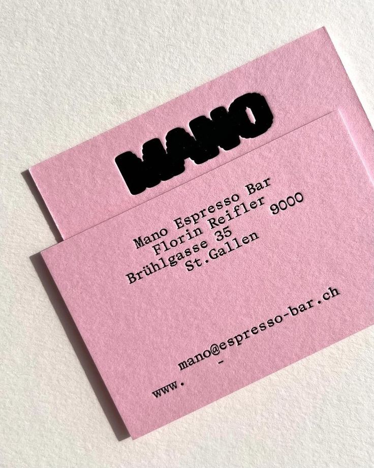 a pink business card with the word nano printed in black on it, sitting on top of a white surface