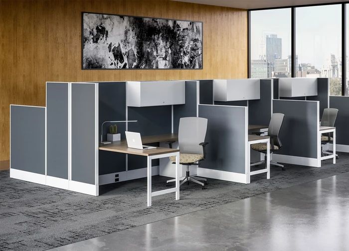 an office cubicle with two desks and chairs in front of a large window