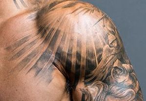 the back of a man's head with tattoos on it