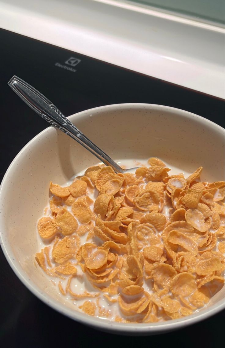 a bowl of cereal with a spoon in it on top of a stove burner