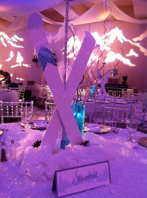 a table set up for an event with snow on the ground and lights in the background