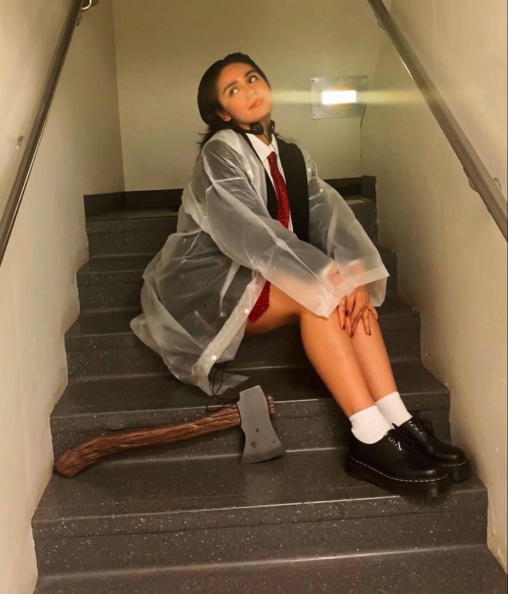 a woman sitting on the stairs with an ax in her hand