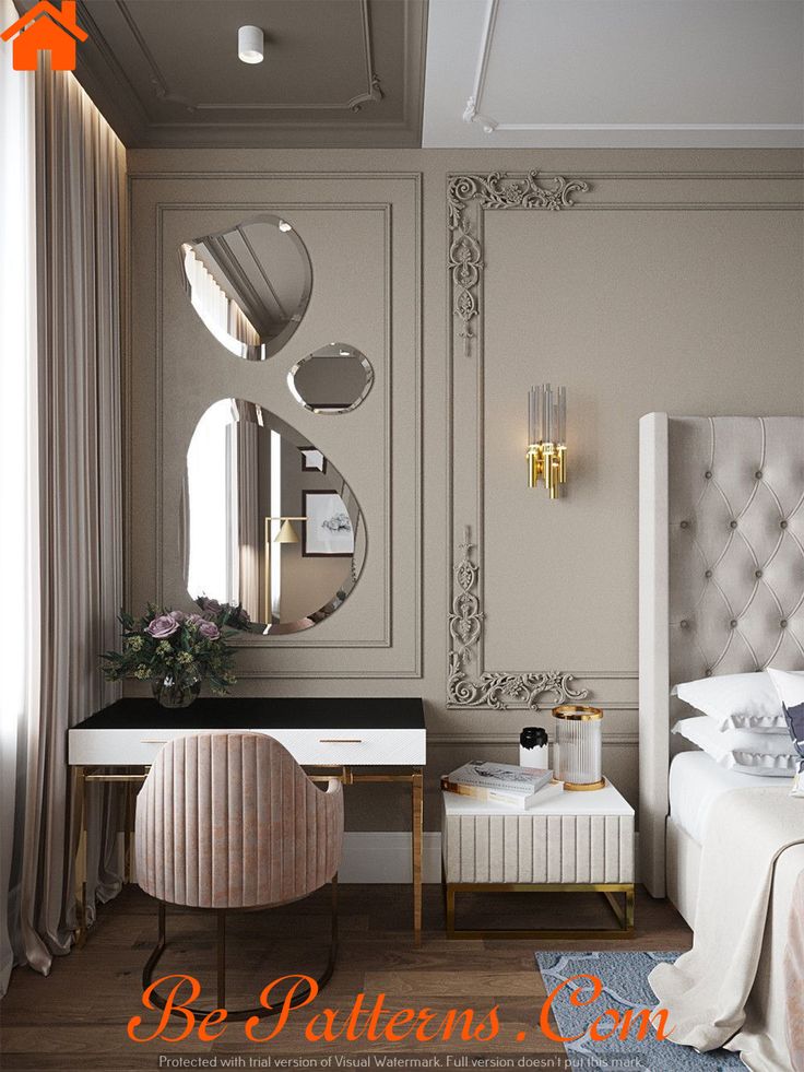 a white bed sitting next to a desk with a mirror on it's wall